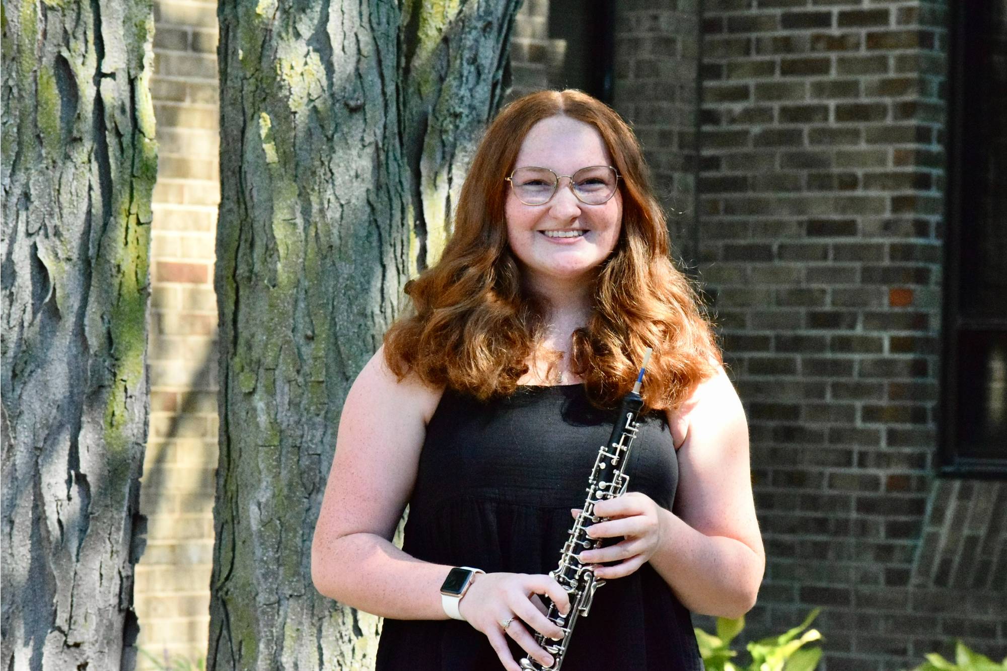 Natalie Kline standing outside and holding her oboe.